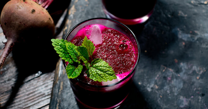Gepresster Rote Beete Saft serviert mit Eiswürfeln und Minze
