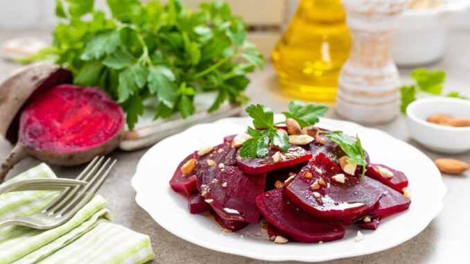 Rote Beete auf einem weißen Teller, daneben Olivenöl und Gemüse