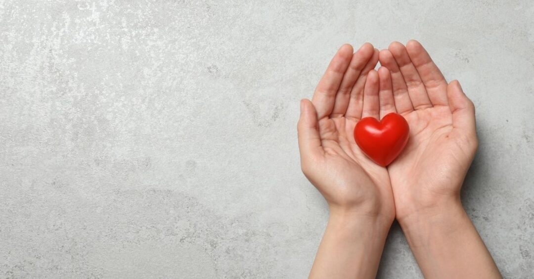 Hände mit rotem Herz als Symbol für Prävention und Rote Bete Herzgesundheit