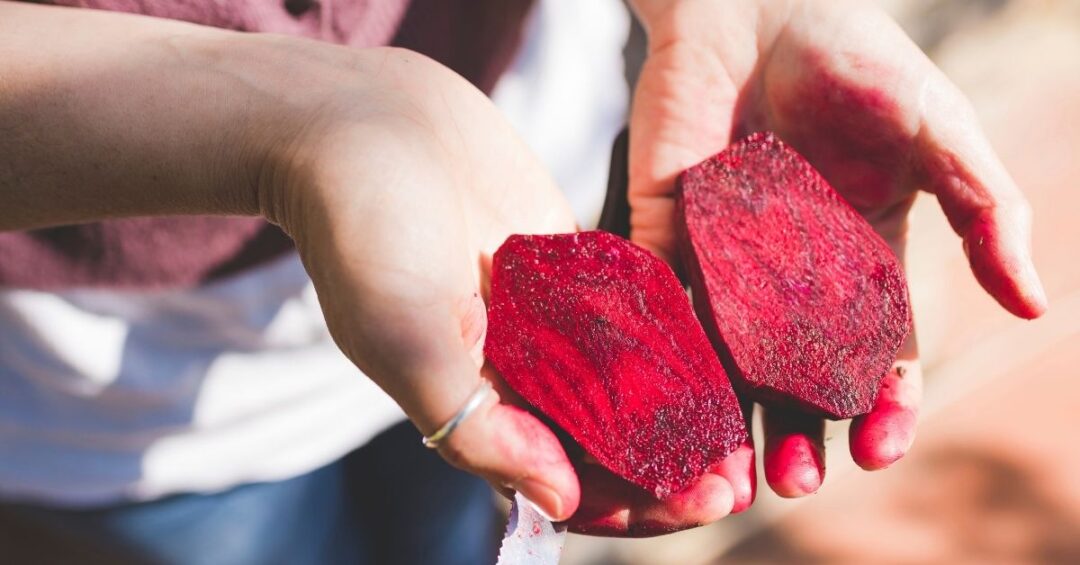 Frisch geschnittene Rote Bete in Händen als Symbol für natürliche Rote Bete Inhaltsstoffe