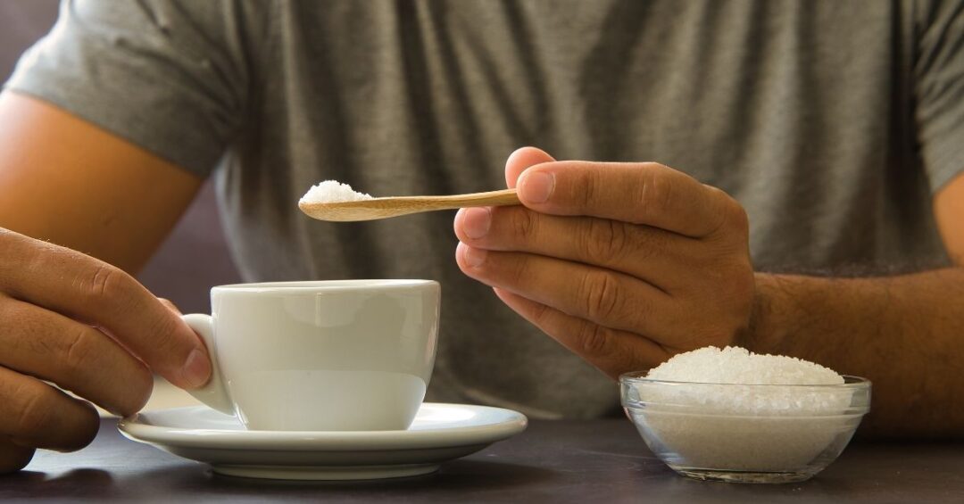 Zucker im Kaffee als Beispiel für Ernährungsgewohnheiten, die Blutzucker, Stoffwechsel und Lebergesundheit beeinflussen können.